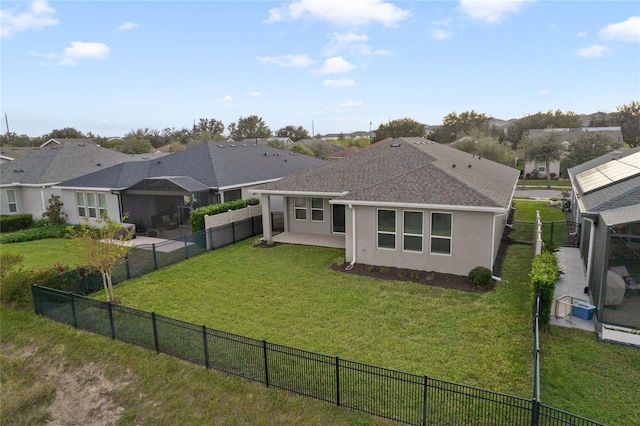 back of house with a yard and a patio