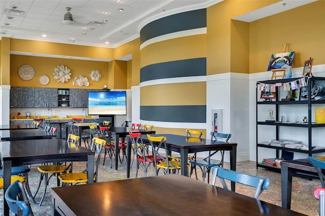 interior space featuring ceiling fan, crown molding, and a towering ceiling