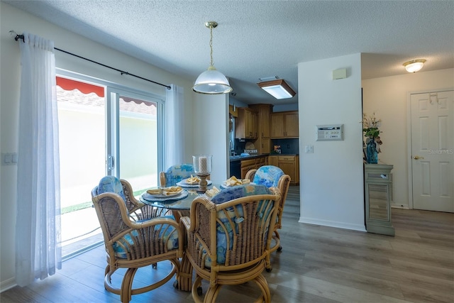 dining room featuring light hardwood / wood-style flooring and a textured ceiling