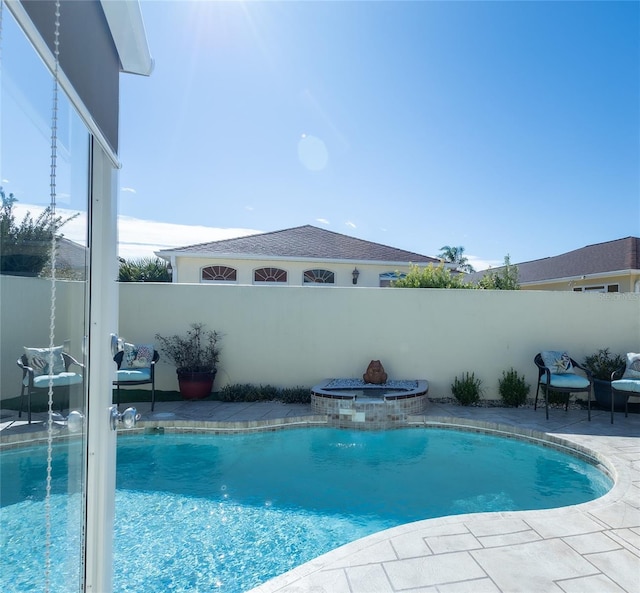 view of swimming pool with an in ground hot tub