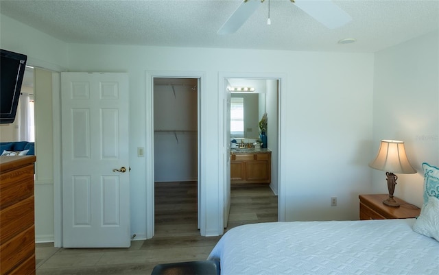 bedroom with ceiling fan, a textured ceiling, and light hardwood / wood-style flooring