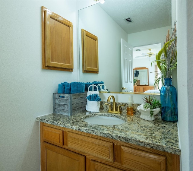 bar featuring a textured ceiling, light stone counters, and sink