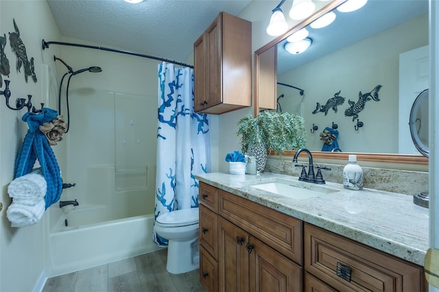 full bathroom with shower / bath combo, hardwood / wood-style floors, a textured ceiling, toilet, and vanity