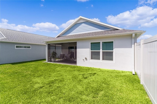 back of property with a yard and a sunroom