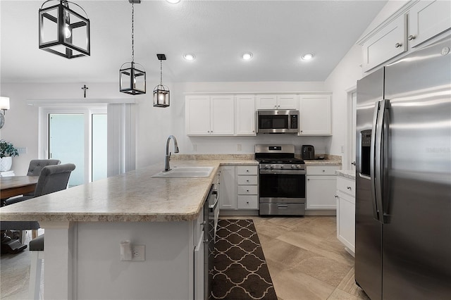 kitchen with stainless steel appliances, vaulted ceiling, sink, decorative light fixtures, and white cabinetry