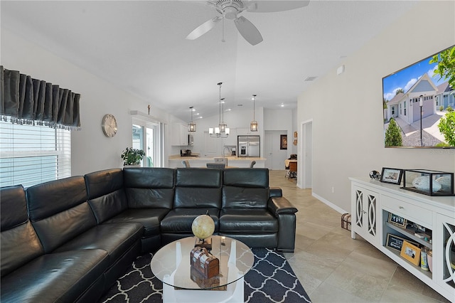 tiled living room with ceiling fan and vaulted ceiling