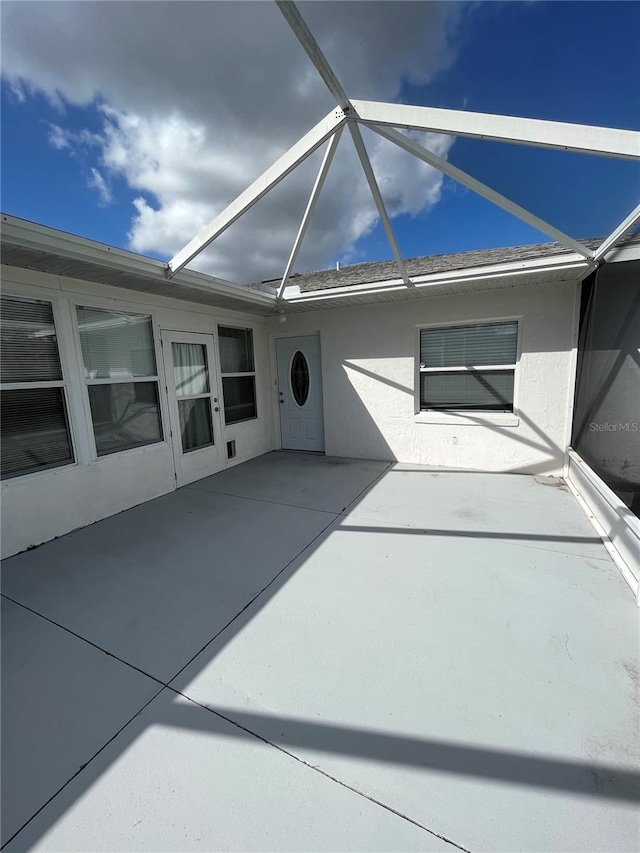 view of patio featuring glass enclosure