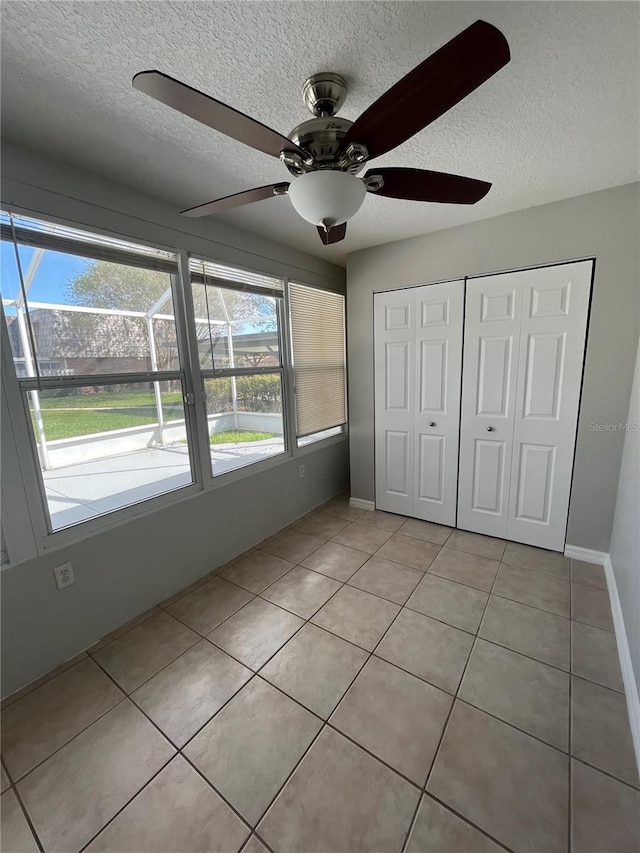 unfurnished bedroom with multiple windows, a textured ceiling, and ceiling fan