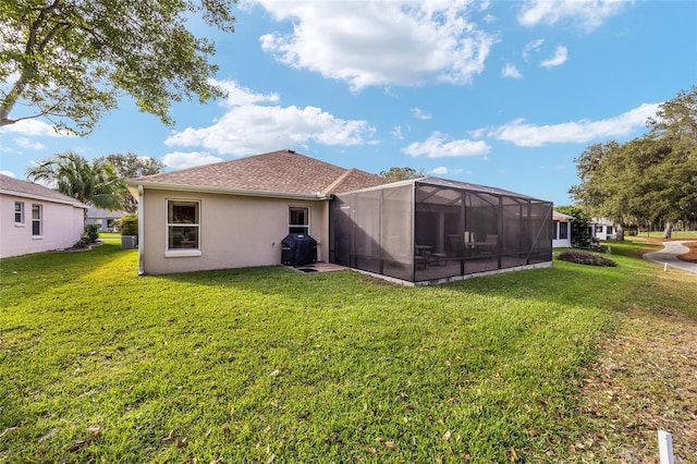 back of house with a lanai and a lawn