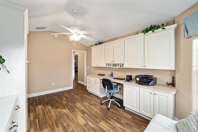 office with ceiling fan, dark wood-type flooring, a textured ceiling, lofted ceiling, and built in desk