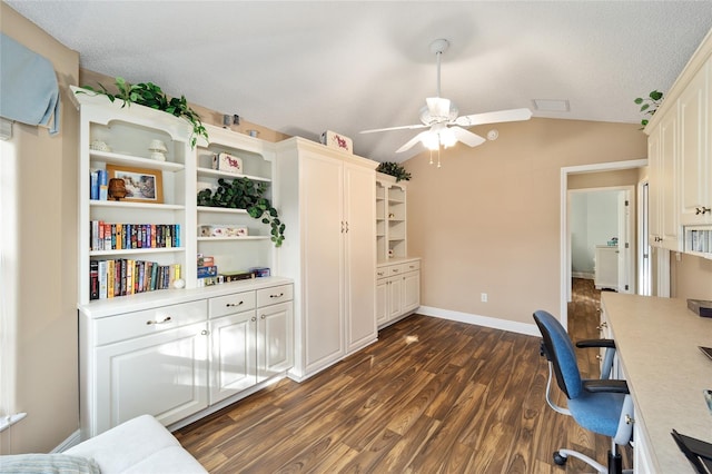 office space with a textured ceiling, vaulted ceiling, ceiling fan, and dark wood-type flooring