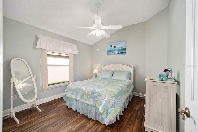 bedroom featuring a textured ceiling, ceiling fan, dark wood-type flooring, and vaulted ceiling