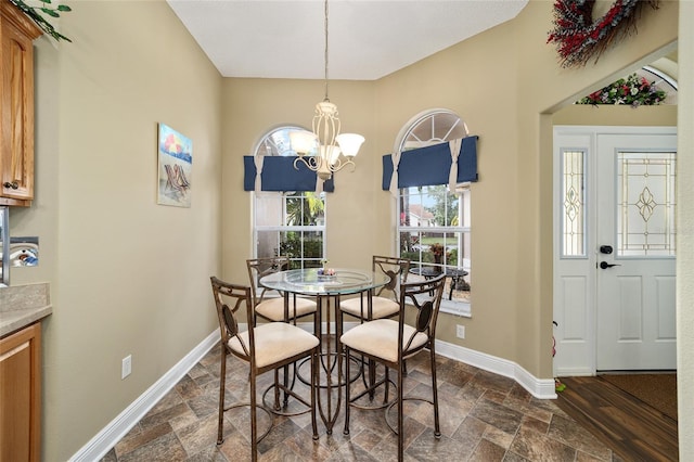 dining area featuring dark wood-type flooring and an inviting chandelier