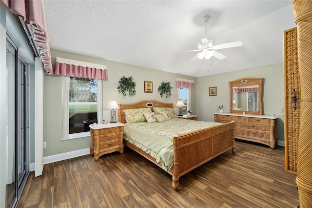 bedroom featuring multiple windows, a textured ceiling, dark hardwood / wood-style flooring, and ceiling fan