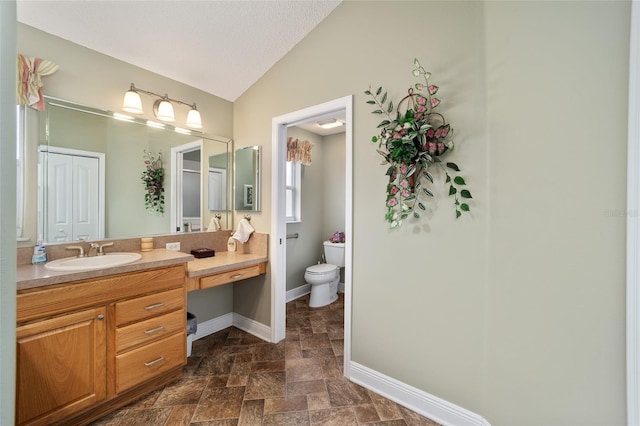 bathroom featuring vanity, toilet, lofted ceiling, and a textured ceiling