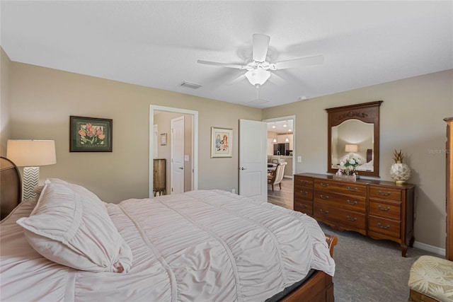 carpeted bedroom featuring connected bathroom and ceiling fan