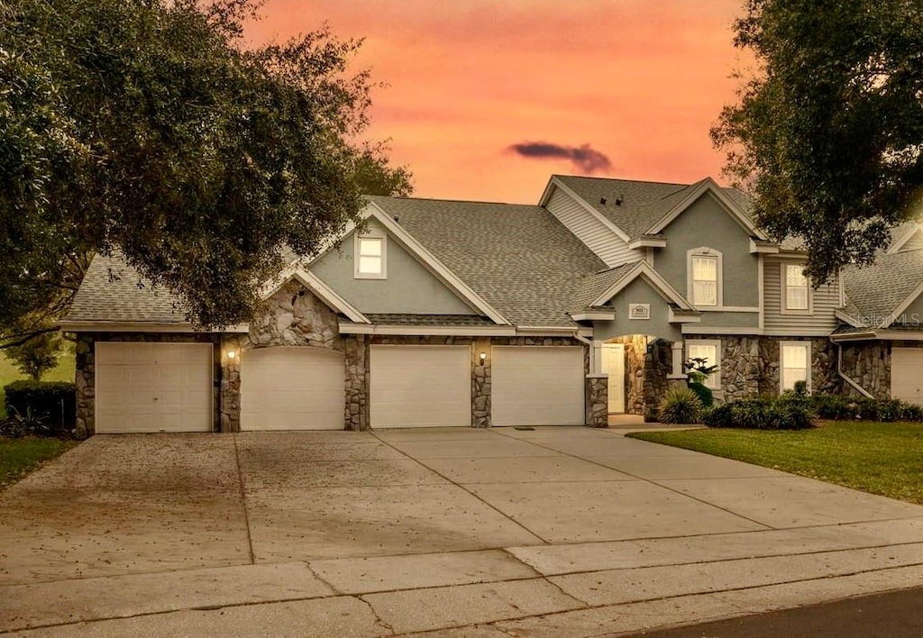 craftsman inspired home featuring a garage and a yard