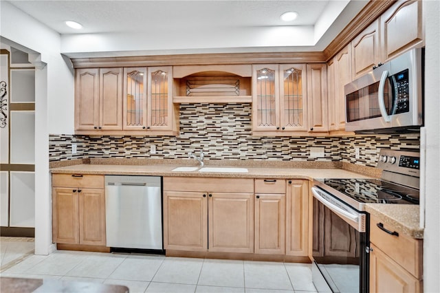 kitchen with sink, tasteful backsplash, light brown cabinetry, light tile patterned floors, and appliances with stainless steel finishes