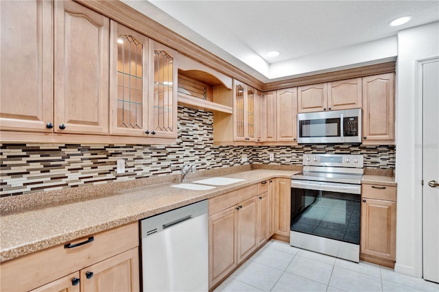 kitchen featuring appliances with stainless steel finishes, backsplash, sink, light brown cabinets, and light tile patterned flooring