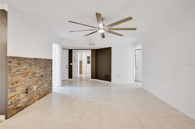 tiled spare room with ceiling fan