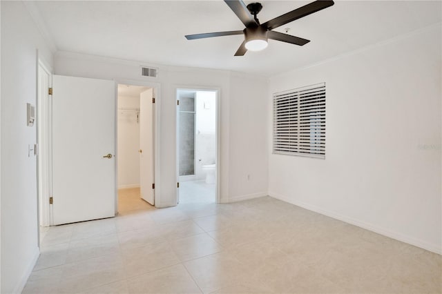 tiled spare room featuring ceiling fan and crown molding