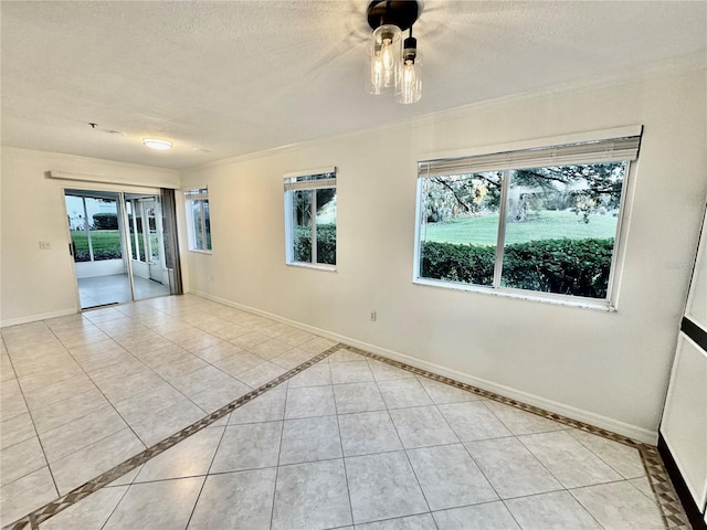 tiled empty room with ornamental molding, a textured ceiling, and a healthy amount of sunlight