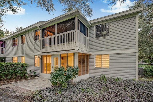 back of property featuring a balcony and a patio