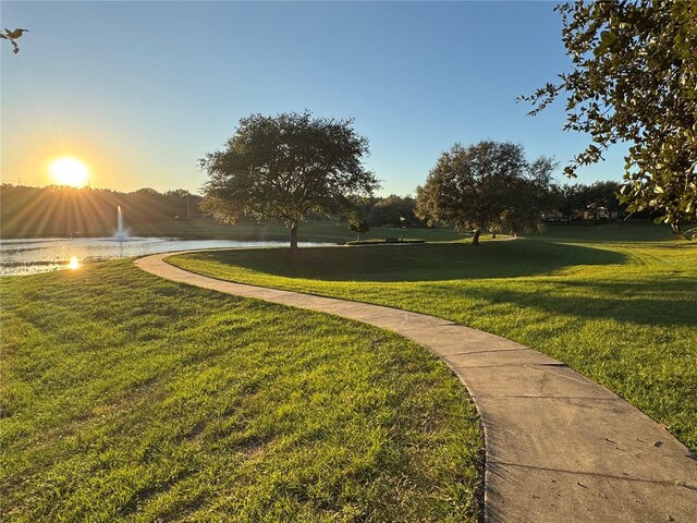 view of home's community featuring a lawn and a water view