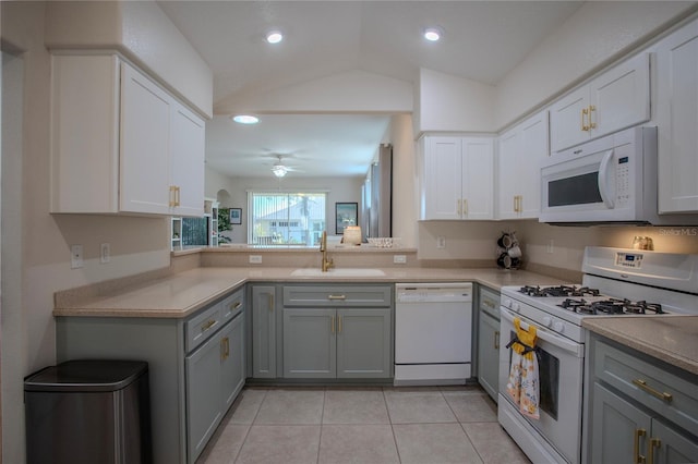 kitchen featuring gray cabinetry, white appliances, vaulted ceiling, sink, and light tile patterned floors