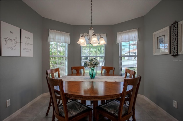 dining space featuring tile patterned floors and a chandelier