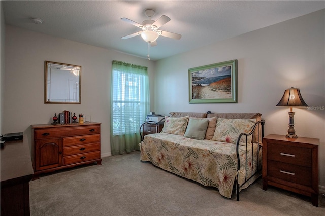 carpeted bedroom with ceiling fan and a textured ceiling