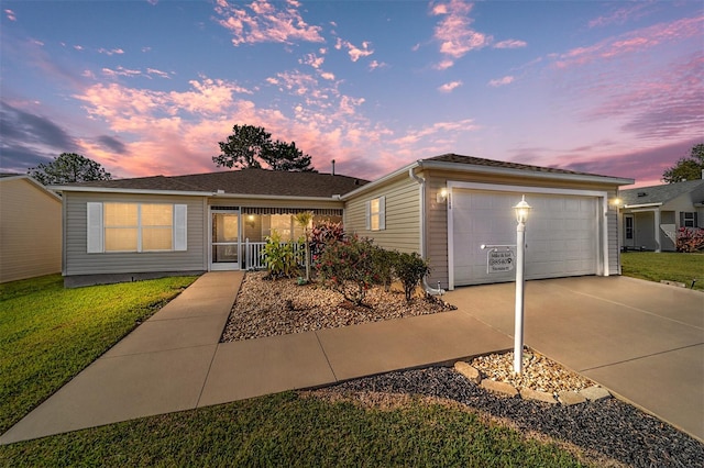 ranch-style home with a garage and a yard