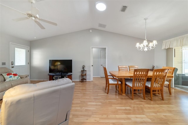 dining area with ceiling fan with notable chandelier, light hardwood / wood-style floors, and lofted ceiling