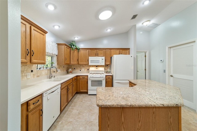 kitchen with sink, a center island, light stone counters, vaulted ceiling, and white appliances