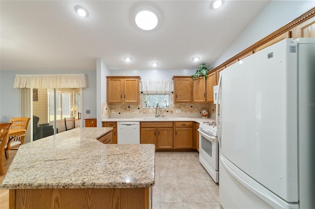 kitchen with a healthy amount of sunlight, sink, white appliances, and backsplash