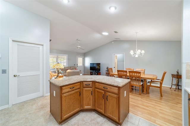 kitchen with ceiling fan with notable chandelier, vaulted ceiling, light hardwood / wood-style floors, decorative light fixtures, and a kitchen island