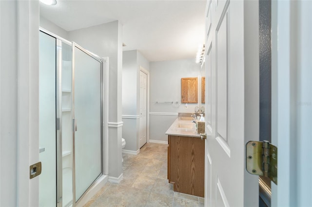 bathroom with an enclosed shower, vanity, and toilet