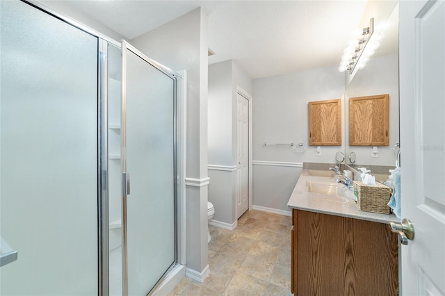 bathroom with vanity, a shower with shower door, and toilet