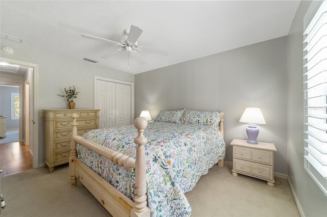 carpeted bedroom featuring ceiling fan and a closet