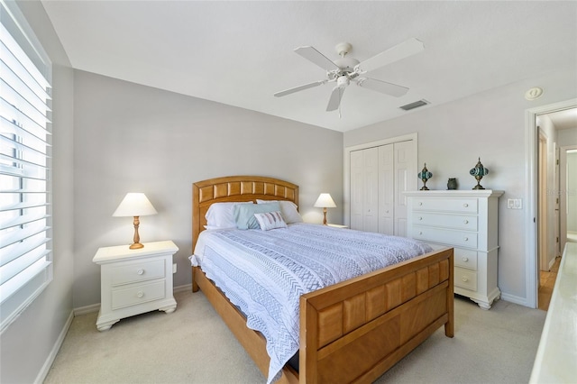 carpeted bedroom with ceiling fan and a closet