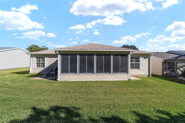 rear view of house with a sunroom and a lawn