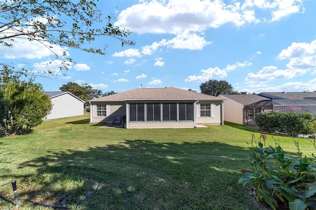 rear view of house with a lawn and a sunroom