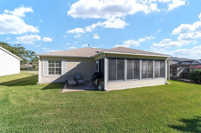 back of property with a lawn, a patio area, and a sunroom