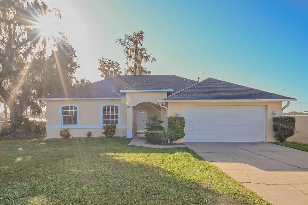 single story home with a garage and a front yard