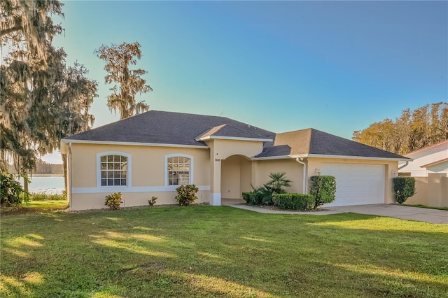 ranch-style home with a front yard, a water view, and a garage