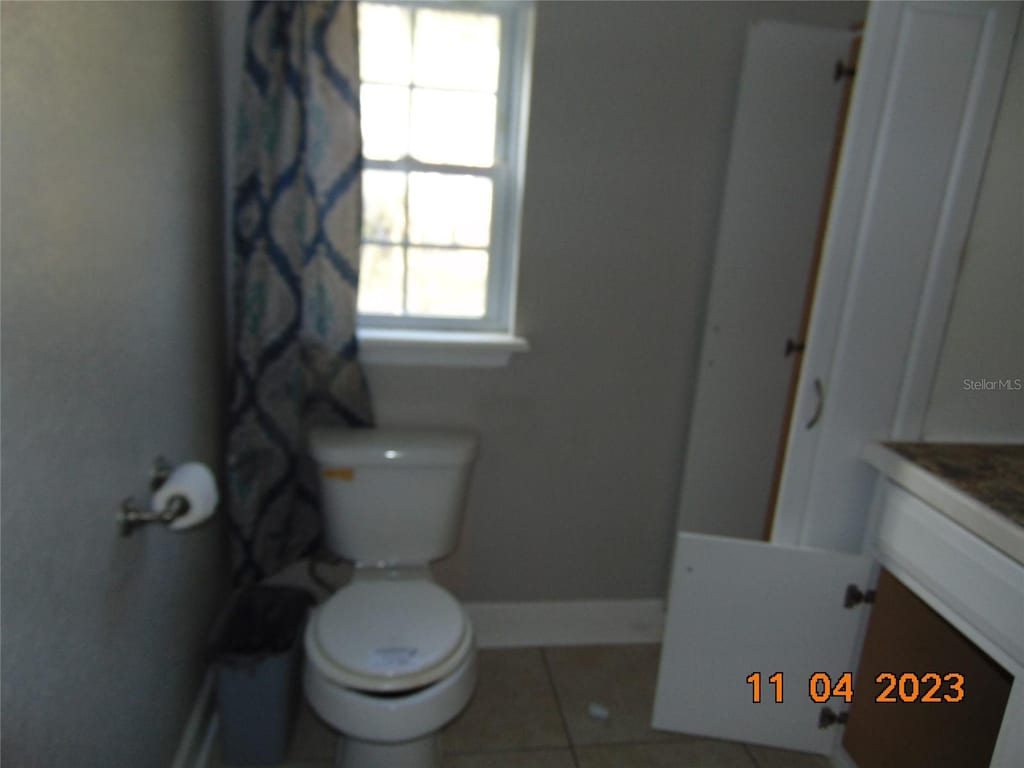 bathroom with tile patterned flooring, vanity, and toilet