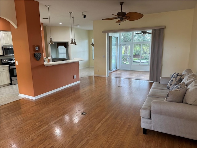 living room with light wood-type flooring and ceiling fan