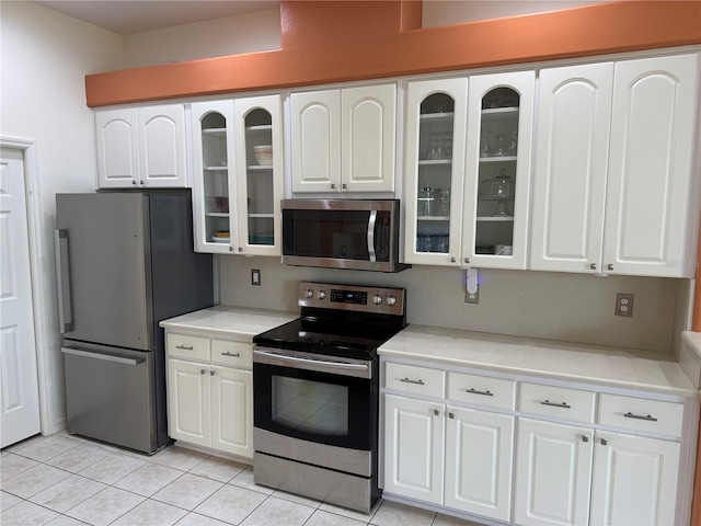 kitchen with white cabinets, appliances with stainless steel finishes, and light tile patterned floors