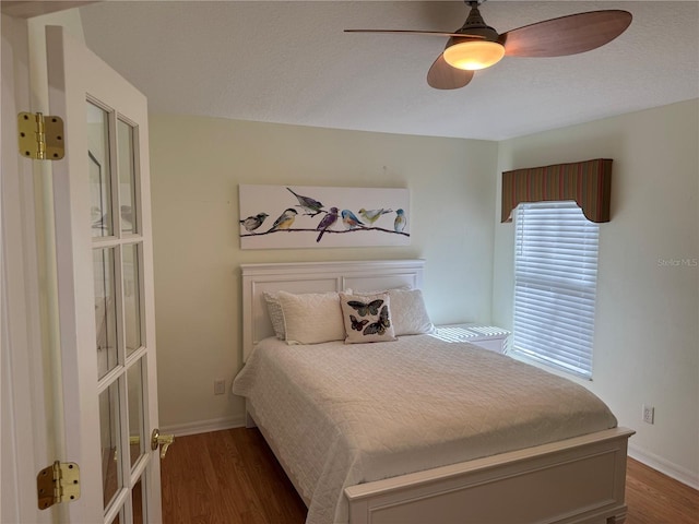 bedroom with dark hardwood / wood-style floors and ceiling fan