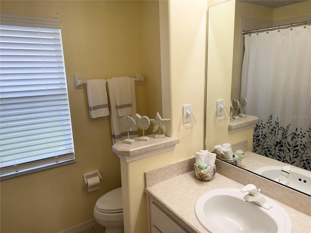 bathroom featuring vanity, curtained shower, and toilet